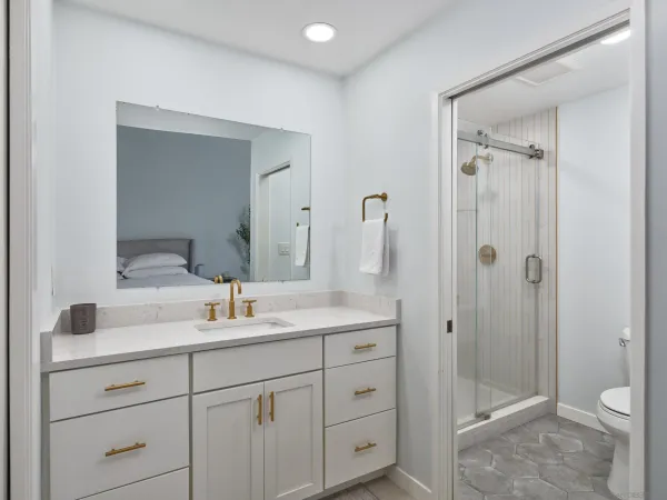 a bathroom with a shower sink vanity mirror and toilet