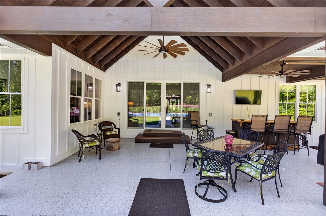 921 Falling Waters Lane Seneca, SC 29672 - Photo 35 of 46 An inviting covered patio with exposed beam ceilings and a large fan, perfect for entertaining by the pool.