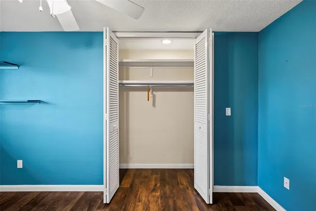 a view of a white house with a big yard and potted plants