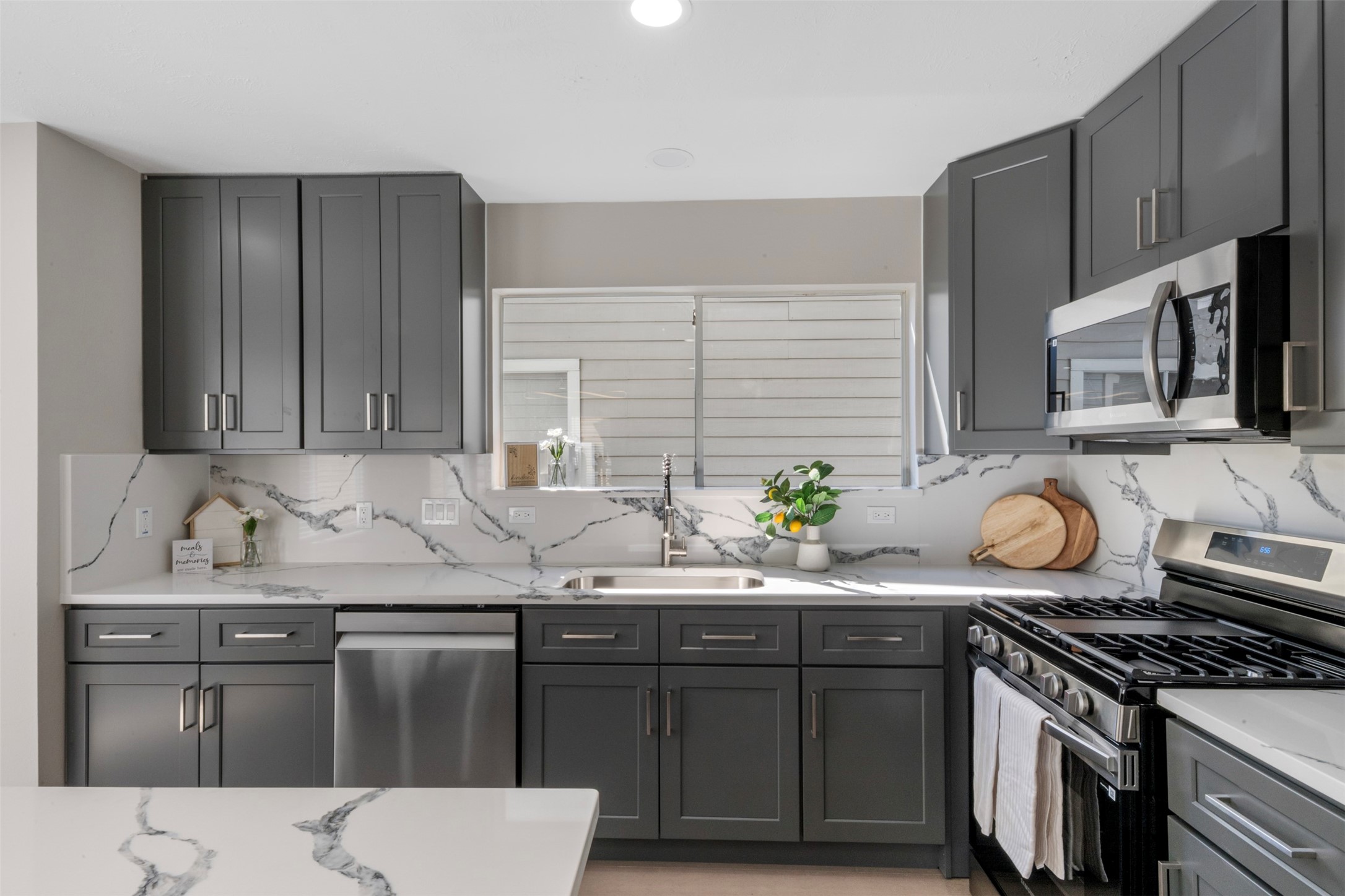 9606 Farrell Drive Houston, TX 77070 - Photo 12 of 37 a kitchen with stainless steel appliances granite countertop a stove a sink and a microwave