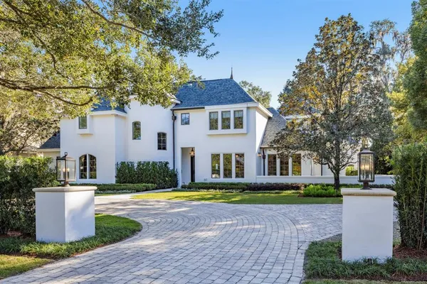 a view of a white house with a swimming pool and a yard