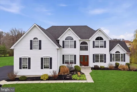a front view of a house with a garden and plants