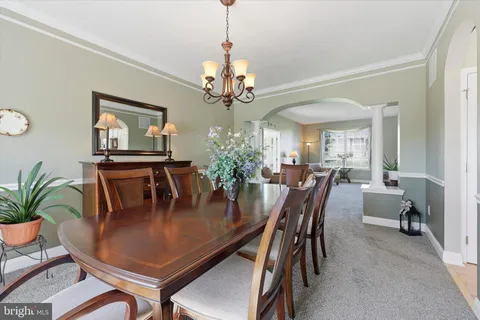 a dining room with furniture potted plants and wooden floor