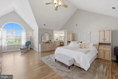 a spacious bedroom with a bed a table and a chandelier