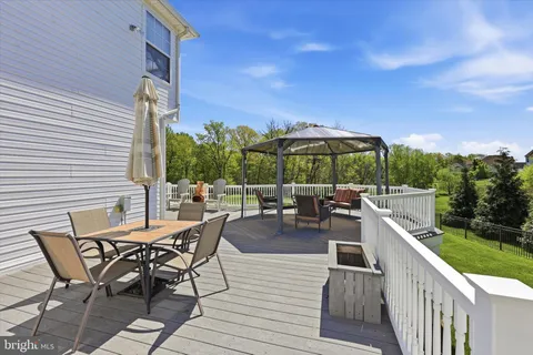 a view of a patio with a table and chairs under an umbrella with wooden fence