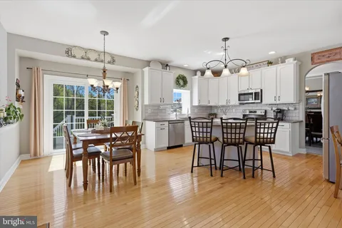 a dining area with furniture window and wooden floor