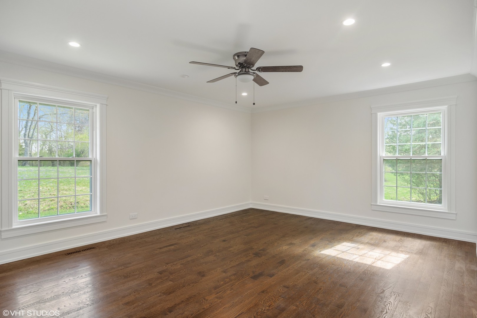 1652 Banbury Road Inverness, IL 60067 - Photo 12 of 28 an empty room with wooden floor ceiling fan and windows