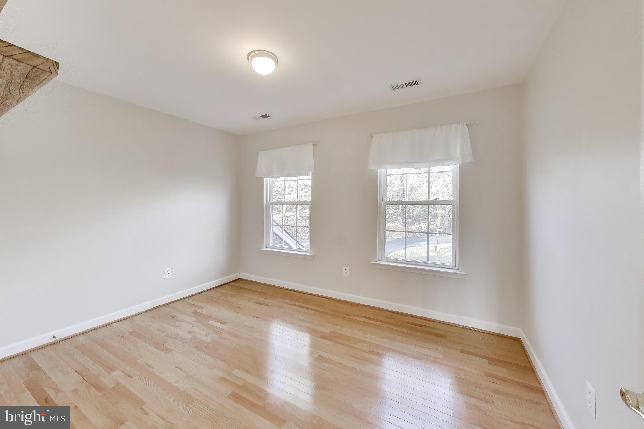2623 Sequoia Way Prince Frederick, MD 20678 - Photo 32 of 57 an empty room with wooden floor and windows