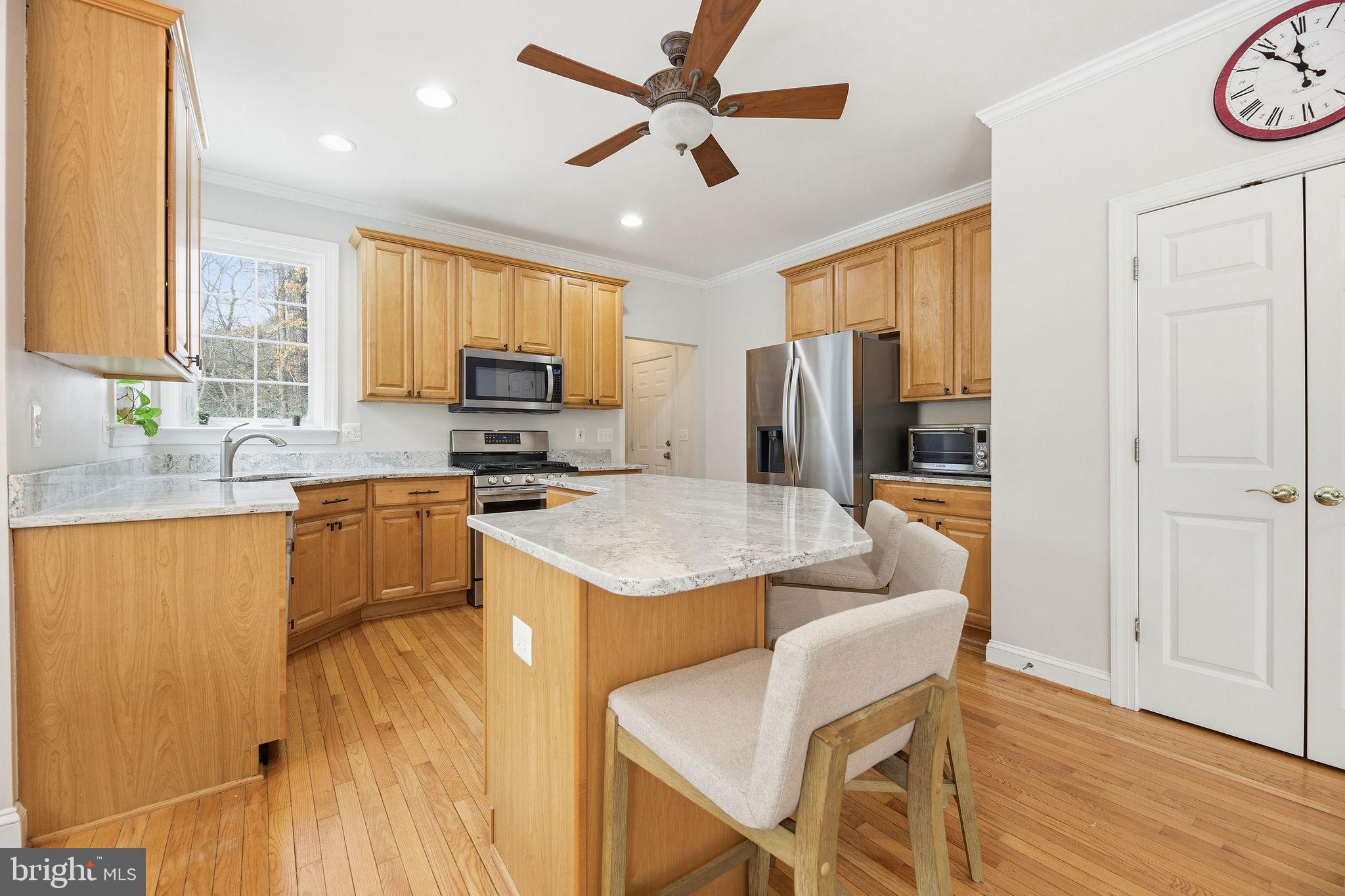 2623 Sequoia Way Prince Frederick, MD 20678 - Photo 4 of 57 a kitchen with stainless steel appliances granite countertop a sink a stove a refrigerator cabinets and a dining table with wooden floor