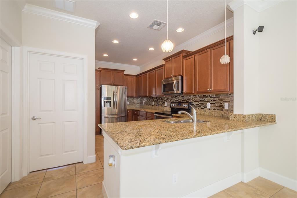 12012 Talitha Lane Orlando, FL 32827 - Photo 10 of 29 a kitchen with stainless steel appliances granite countertop a sink refrigerator and cabinets