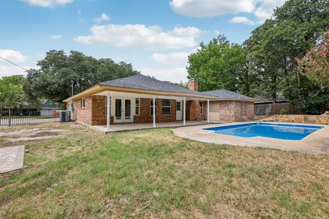 a view of house with swimming pool and yard