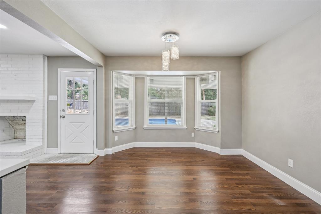 1033 Oak Ridge Drive Azle, TX 76020 - Photo 12 of 30 a view of an empty room with wooden floor and a window
