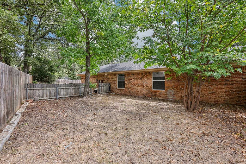 1033 Oak Ridge Drive Azle, TX 76020 - Photo 26 of 30 a front view of a house with a yard and garage