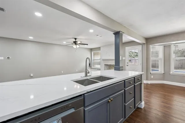 a kitchen with a sink and wooden floor