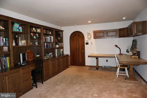 a view of a workspace with furniture and a book shelf
