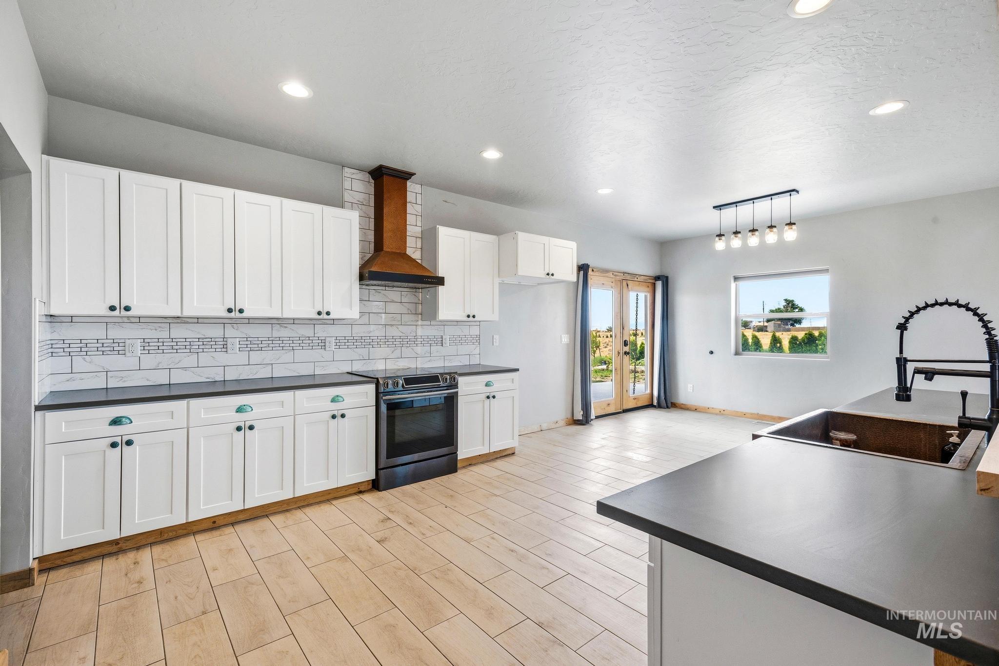 870 Desert Wind Road Boise, ID 83716 - Photo 6 of 50 Expansive living area featuring a floor-to-ceiling stone fireplace, high ceilings, wood-finish flooring, and exposed wood beam accents