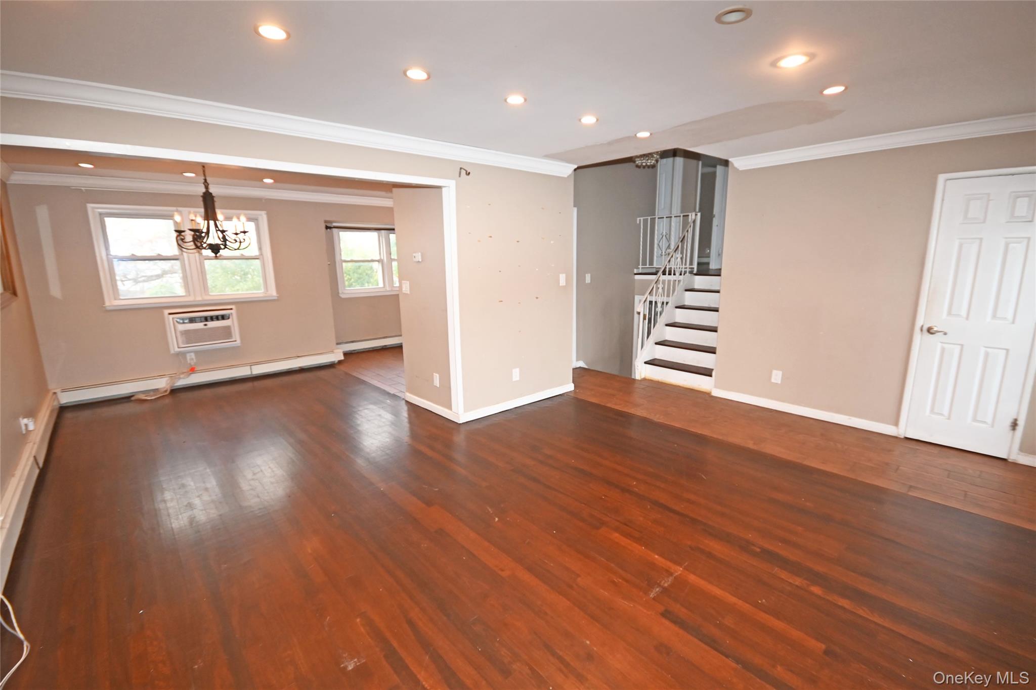 89 Osborne Road West Hempstead, NY 11552 - Photo 28 of 50 Unfurnished living room with crown molding, recessed lighting, stairway, a wall mounted air conditioner, and dark wood-type flooring