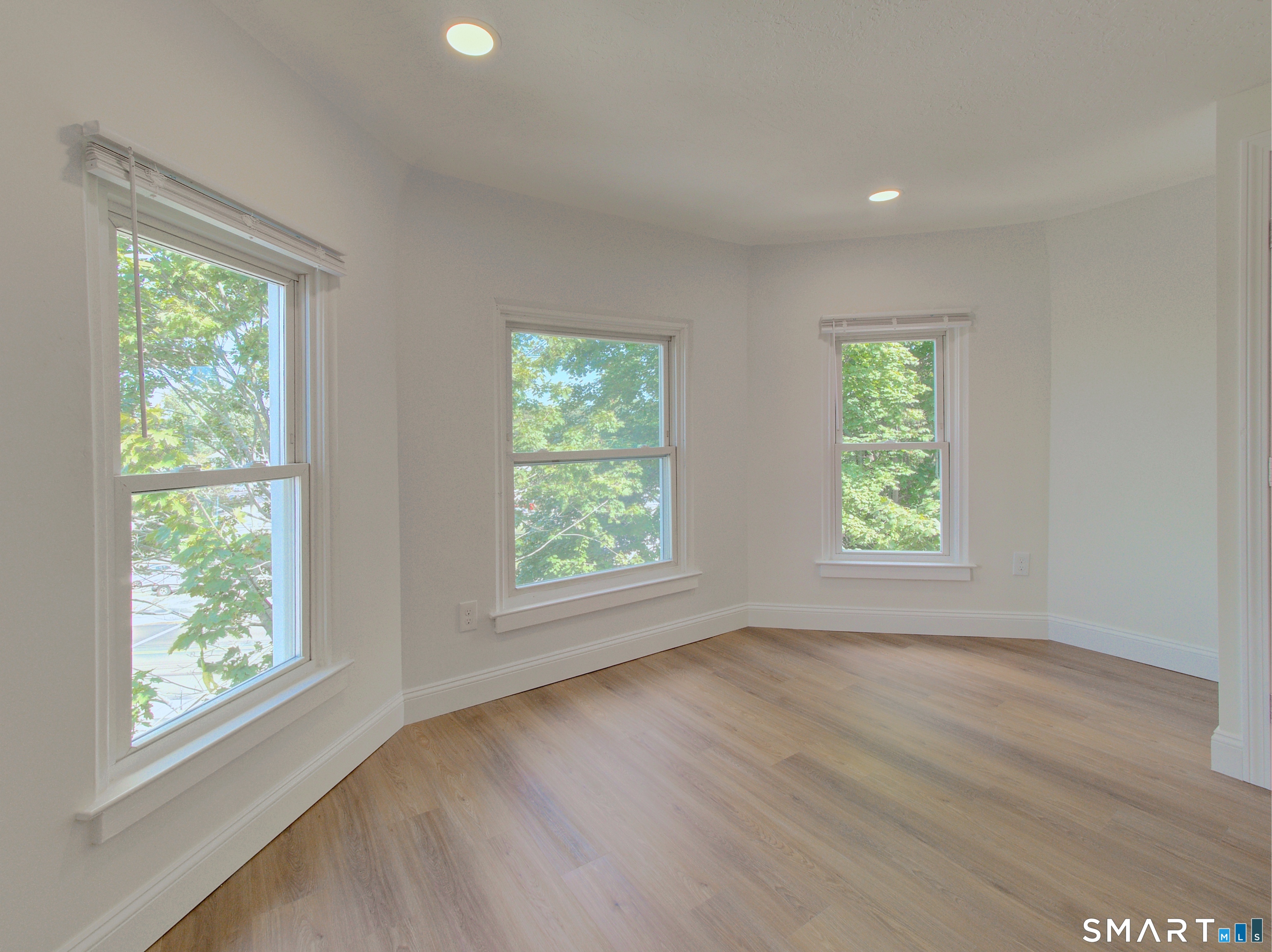 16 Benham Road, Unit D Groton, CT 06340 - Photo 10 of 15 a view of an empty room with wooden floor and a window