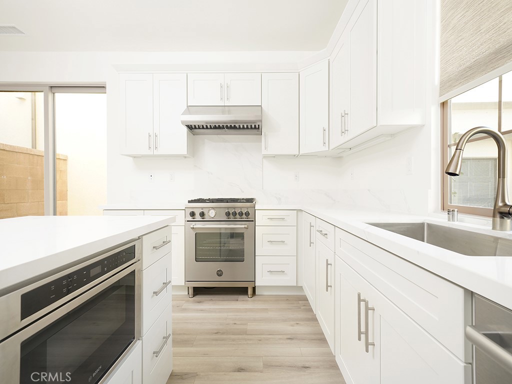 120 Messenger Irvine, CA 92618 - Photo 4 of 26 a kitchen with stainless steel appliances a stove microwave and cabinets
