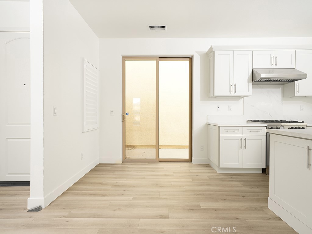 120 Messenger Irvine, CA 92618 - Photo 6 of 26 a view of a kitchen with white cabinets and wooden floor