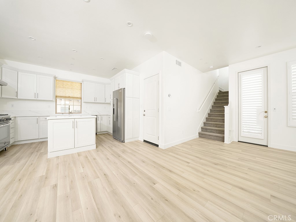 120 Messenger Irvine, CA 92618 - Photo 10 of 26 a view of a kitchen with wooden floor electronic appliances and stairs