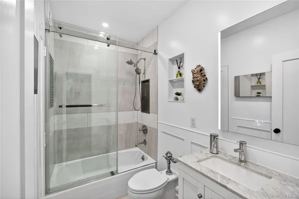 a bedroom with double bed a mirror and a large window