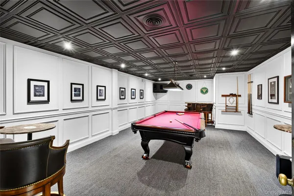 a room with furniture pool table gym equipment wooden floor and windows