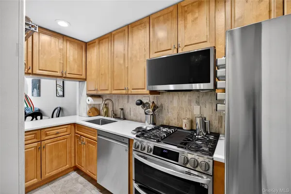 a kitchen with stainless steel appliances a sink stove and microwave
