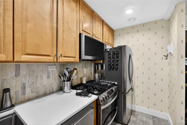 a kitchen with stainless steel appliances a stove a microwave and a refrigerator