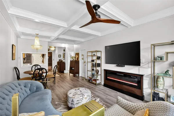 a living room with furniture a chandelier and a flat screen tv