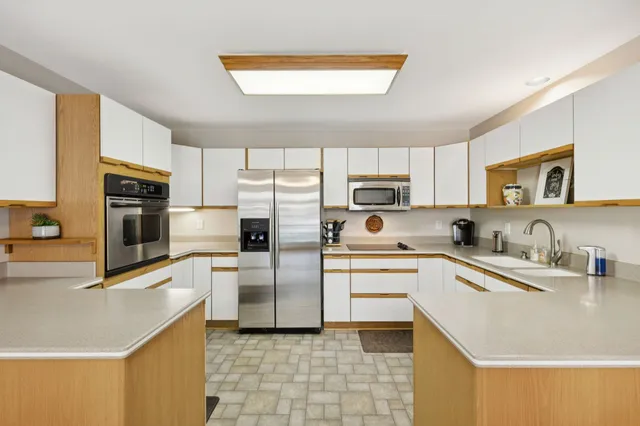 a kitchen with stainless steel appliances a refrigerator sink and microwave