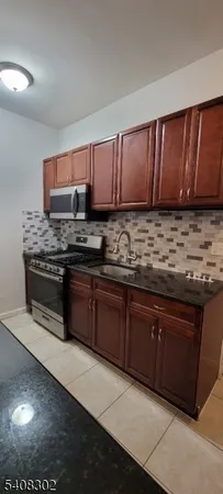 a kitchen with stainless steel appliances granite countertop wooden cabinets a stove top oven a sink and dishwasher