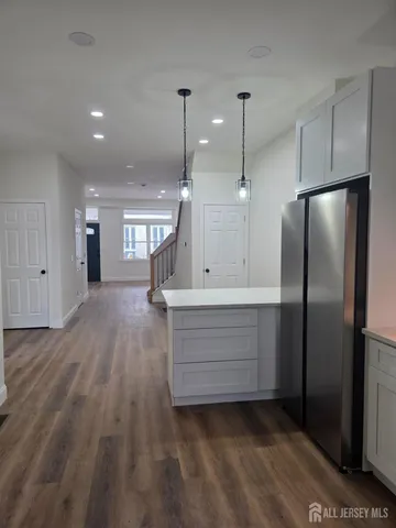 a kitchen with kitchen island white cabinets and stainless steel appliances