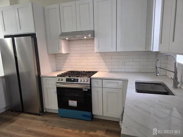 a kitchen with white cabinets and a stove top oven