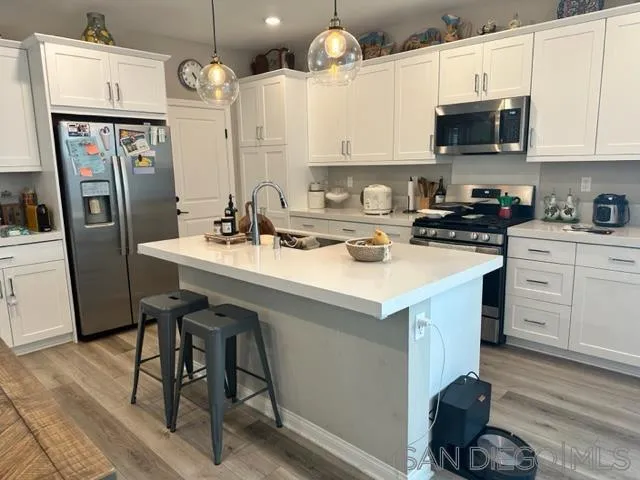 1767 Whitmore Loop Chula Vista, CA 91913 - Photo 8 of 22 a kitchen with stainless steel appliances a stove a sink a microwave a refrigerator and cabinets