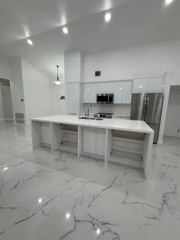 a view of kitchen with stainless steel appliances cabinets and window