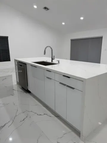 a kitchen with sink and mirror