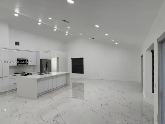 a view of kitchen with stainless steel appliances a refrigerator and a stove top oven