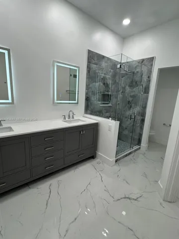 a bathroom with double vanity sink and mirror