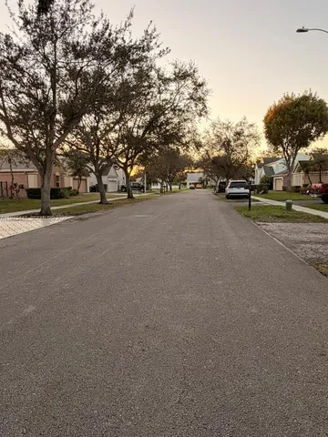 a view of a street with a building and trees