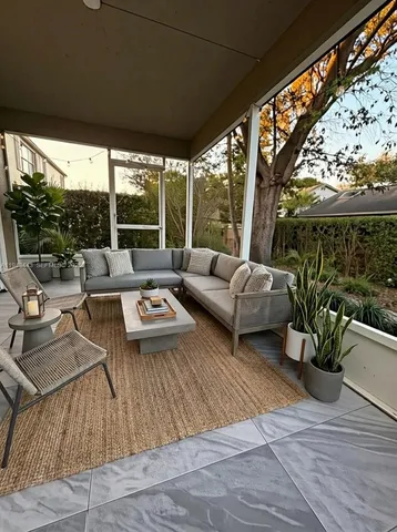 a living room with patio furniture and garden