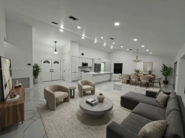 a living room with furniture and a view of kitchen