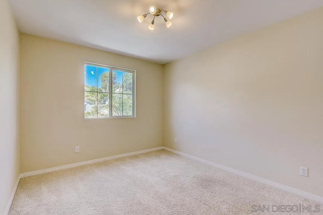 551 Dundee Lane San Marcos, CA 92069 - Photo 12 of 30 an empty room with a chandelier fan and window