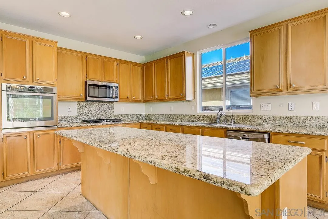 551 Dundee Lane San Marcos, CA 92069 - Photo 2 of 30 a kitchen with granite countertop a sink and cabinets