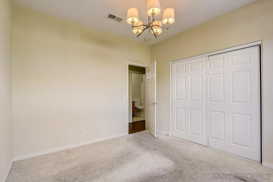 551 Dundee Lane San Marcos, CA 92069 - Photo 28 of 30 an empty room with a chandelier fan and closet