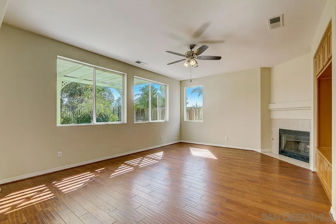 551 Dundee Lane San Marcos, CA 92069 - Photo 3 of 30 a view of an empty room with a window and wooden floor