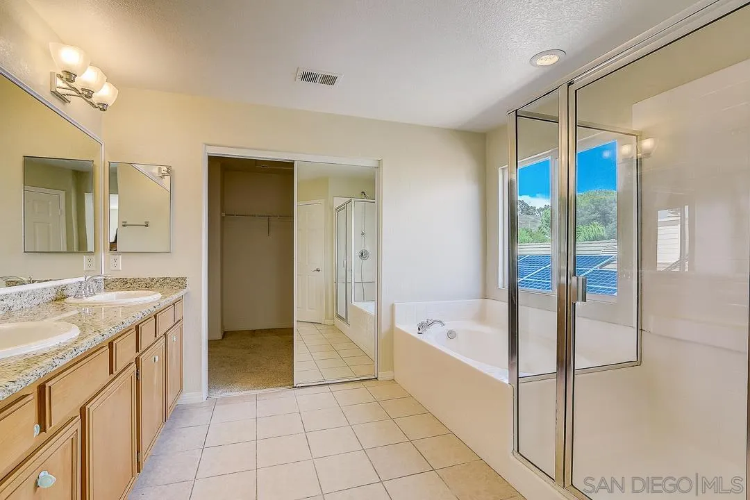 551 Dundee Lane San Marcos, CA 92069 - Photo 4 of 30 a spacious bathroom with a tub shower and sink