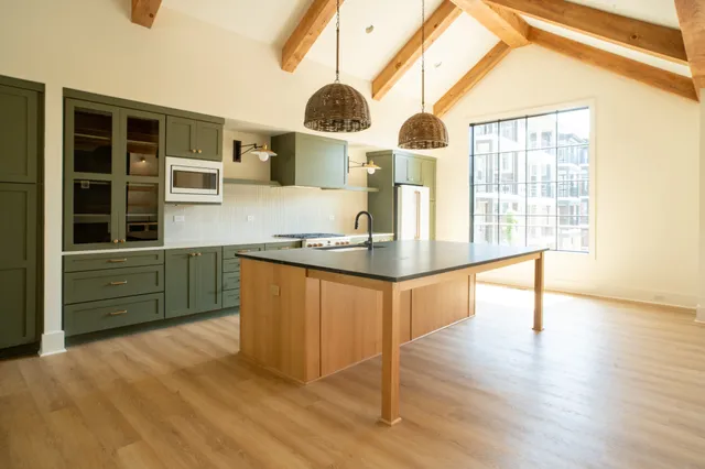 a kitchen with stainless steel appliances granite countertop a stove a sink and a large window