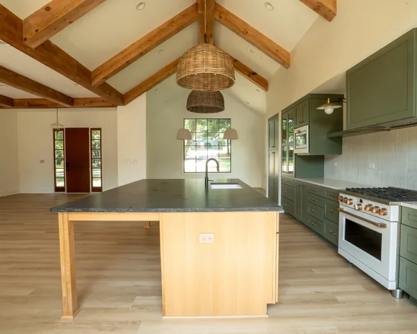a kitchen with stainless steel appliances granite countertop a oven a stove and a wooden floors
