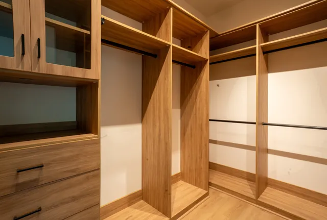 a view of walk in closet with empty racks